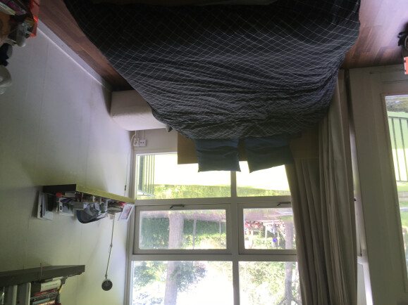 Bed (twee persoons) met links het balkon